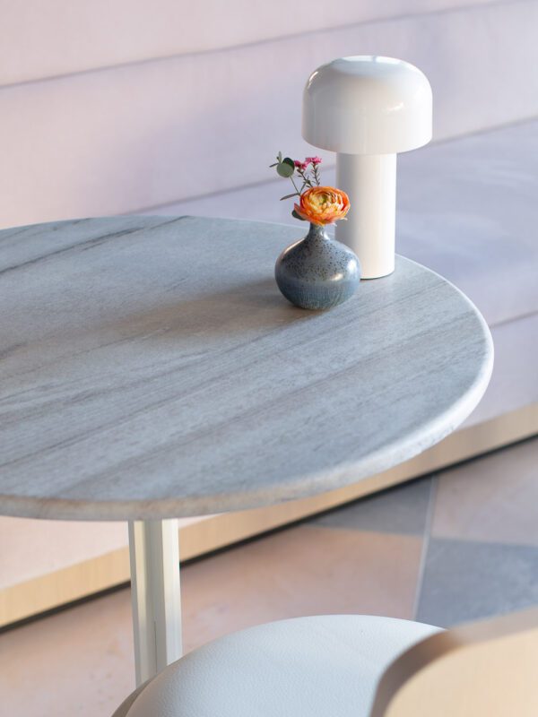 Photo of table with flower in a vase and small mushroom lamp