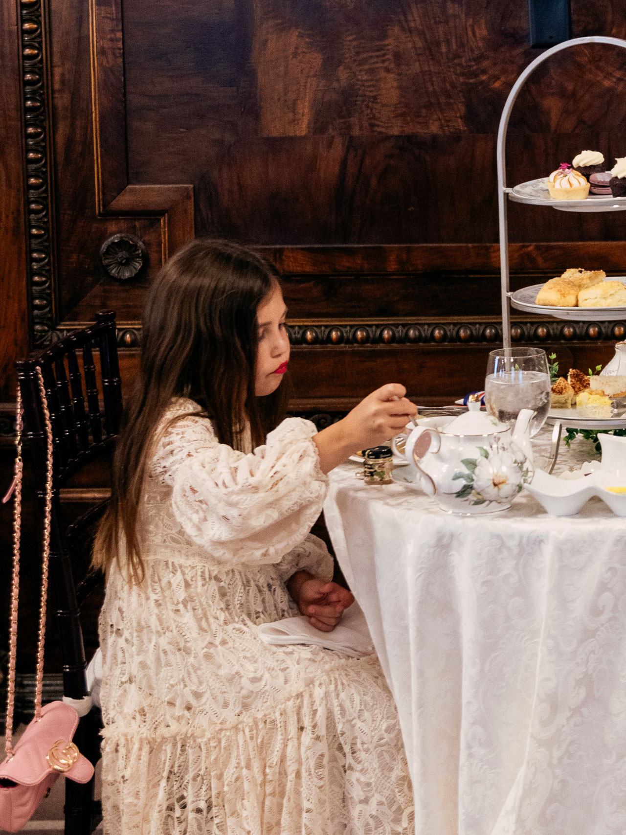 Young girl in a light pink dress enjoying tea at the Hermitage Hotel Ballroom on mothers day.